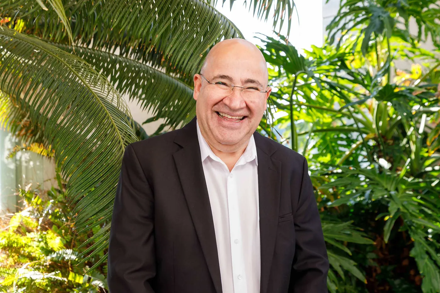 עו"ד שחר שוורץ בחליפה כהה על רקע צמחייה ירוקה
